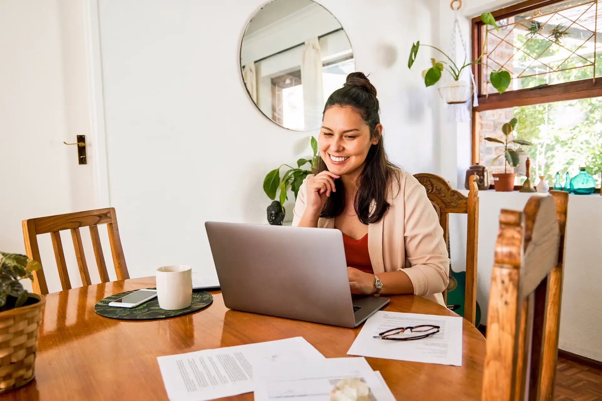 Shot of an attractive young woman using her laptop at the table while working from home