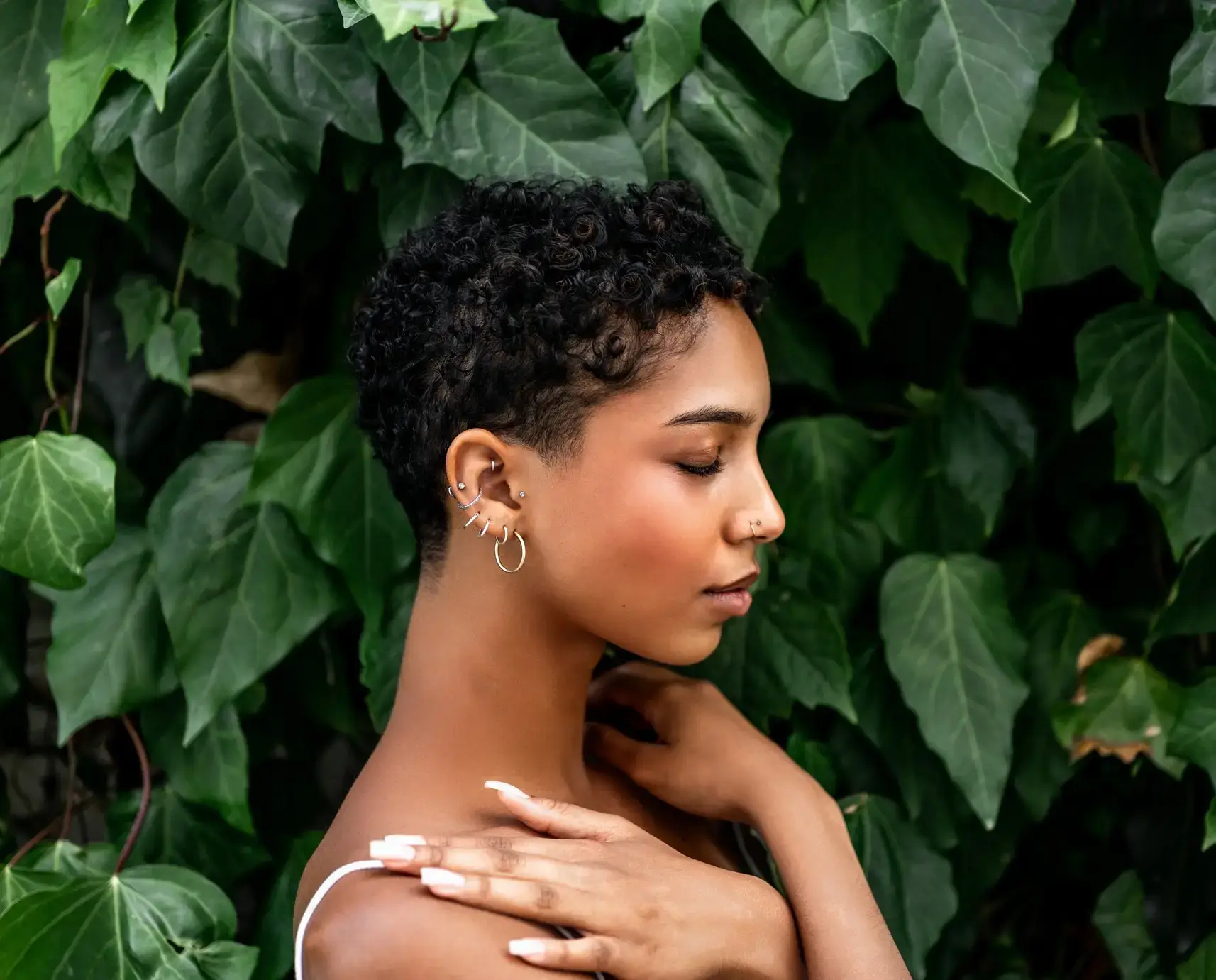 Beautiful young girl posing by the hedge